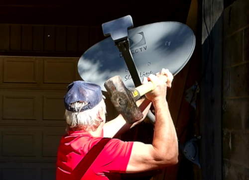 Man smashing satellite dish